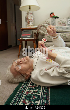 Femmina Senior utilizza un medical alert sistema di allarme per la chiamata di emergenza per aiutare dopo la caduta Foto Stock