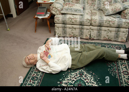 Senior femminile donna utilizza un medical alert sistema di allarme per la chiamata di emergenza per aiutare dopo la caduta Foto Stock