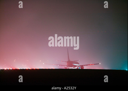 Un piano sulla pista di East Midlands Airport, Leicestershire, Regno Unito, in condizioni di nebbia Foto Stock