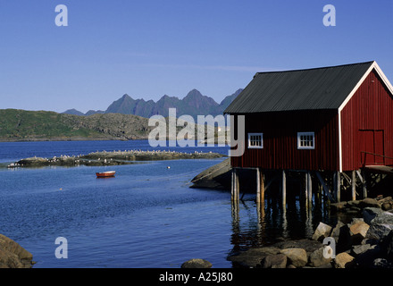 Tipica casa di pescatori chiamato rorbuer davanti al mare in Reine, isola di Moskenes, Isole Lofoten in Norvegia Foto Stock