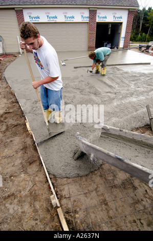 Mason lavoratori cemento pour strada in una nuova casa progetto di costruzione Foto Stock