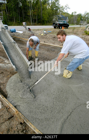 Mason lavoratori cemento pour strada in una nuova casa progetto di costruzione Foto Stock