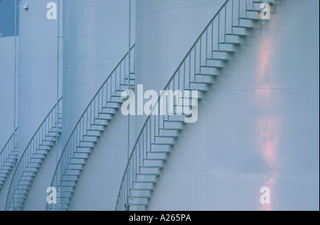 Grafica immagini astratte di quattro grandi olio bianco tamburi di storage con scalinate che si avvolgono intorno ad essi Foto Stock