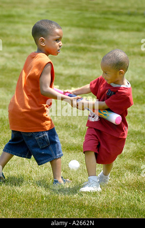 Fratelli giocare a baseball con ciascun altro Foto Stock