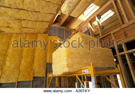 R38 isolamento in fibra di vetro che viene installato nel tetto nuovo stile loft home in costruzione Foto Stock