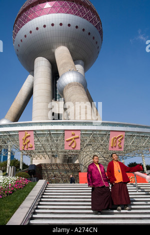 Due monaci cinesi come turisti nella parte anteriore della Oriental Pearl Tower, Pudong, Shanghai, Cina Foto Stock