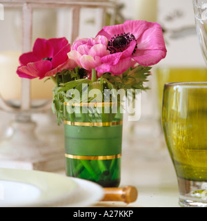 Rosa e un papavero rosso in un vetro verde Foto Stock