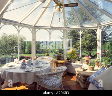 Una veranda con vista a campi aperti al di là e un tavolo da pranzo prevista Foto Stock