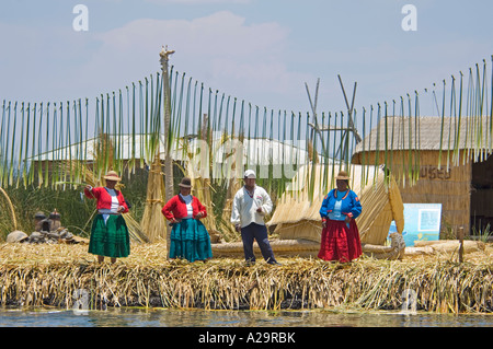 Una famiglia vestito in abiti tradizionali in una delle isole di canne sul lago Titicaca. Foto Stock