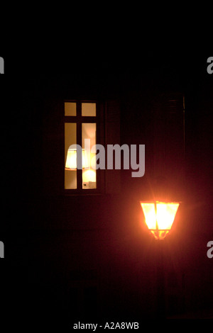 Lampione di fronte a una finestra illuminata illuminata di notte Foto Stock