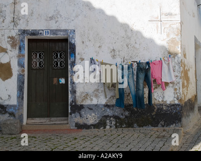Il lavaggio appeso al di fuori di una vecchia casa, Monchique, Algarve, Portogallo. Foto Stock