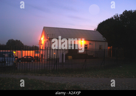 Edificio commerciale con protezione e sicurezza luci accese, come la luce del giorno comincia a svanire, preso in Staffordshire Inghilterra. Foto Stock