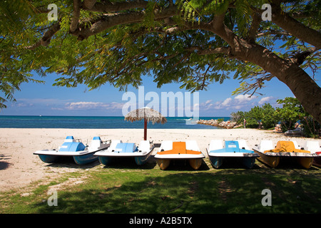 Pedalo boats, ombrellone e albero su di una spiaggia, Guardalavaca, provincia di Holguin, Cuba Foto Stock