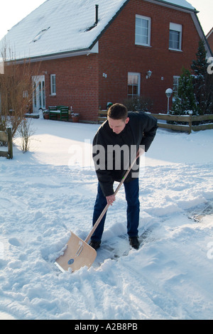 L uomo si sposta la neve dal sentiero Foto Stock