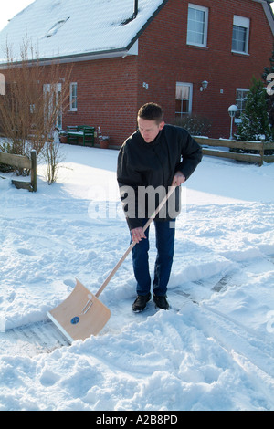 L uomo si sposta la neve dal sentiero Foto Stock