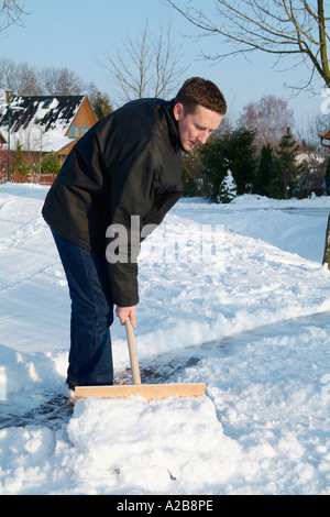 L uomo si sposta la neve dal sentiero Foto Stock