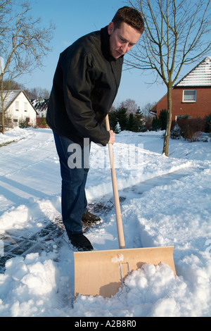 L uomo si sposta la neve dal sentiero Foto Stock