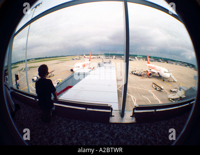 Orologi ragazzo aeromobili presso l'aeroporto di Stansted, Londra Foto Stock