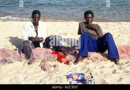 I pescatori riassettavano le reti a Kande Spiaggia al lago Malawi in Africa Foto Stock