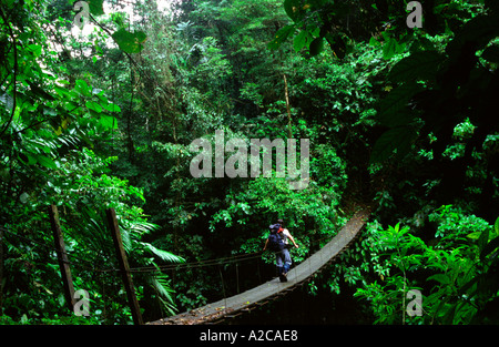 Trekker attraversando un ponte di sospensione. Monteverde Cloud Forest Preserve. Costa Rica Foto Stock