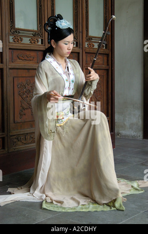 Donna che gioca la musica tradizionale in giardino per indugiare in, Suzhou Cina Foto Stock