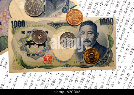 Giapponese Yen 1000 le banconote e le monete metalliche contro un sfondo scritta. Foto Stock