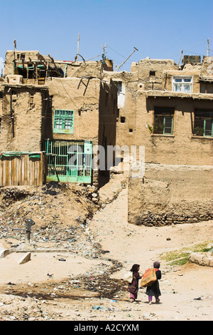 AFGHANISTAN Ghazni bambini camminano con sacchi sulle loro spalle verso le case all'interno delle antiche mura di Cittadella Foto Stock