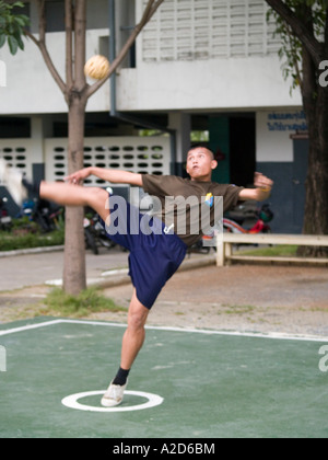 Andando per il kick giovane giocando sepak takraw Thailandia Foto Stock