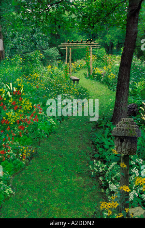 Fatte a mano in stile rustico giardino estivo percorso con giardino fatti a mano arte funzioni utilizzando prodotti da giardino - arbor, birdbox e panca Foto Stock