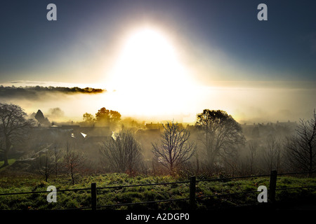 Il sorgere del sole su Shaftesbury nella nebbia di mattina Foto Stock