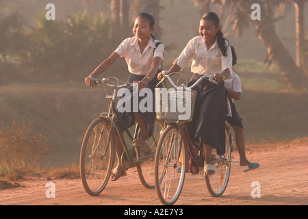 Asia, Cambogia Siem Reap, Angkor Wat, ragazze equitazione biciclette a casa da scuola. Foto Stock