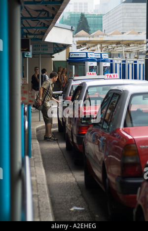 Dh CENTRAL HONG KONG uomo apertura sportello del taxi Traghetto Star taxi Foto Stock