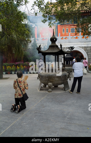 dh po Lin Monastero LANTAU HONG KONG adoratore con bastoni di joss urn tempio persone cina culto incenso buddista cinese preghiera anziana donna Foto Stock