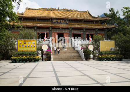 Dh il Monastero Po Lin LANTAU HONG KONG Temple ingresso e giovane salire a piedi a passi joss stick urna del bruciatore Foto Stock