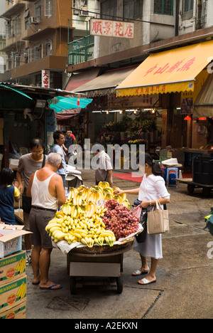 Dh marmo Road Market North Point HONG KONG cliente sta guardando fruttivendolo street stallo di frutta fresca barrow cina Foto Stock