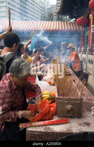 dh Wong Tai Sin Tempio WONG TAI SIN HONG KONG adoratore cibo offerte Joss sticks tempio persone adorare folla tao incenso rituale taoista Foto Stock