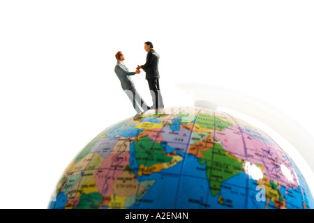 Statuette in piedi sul globo terrestre Foto Stock