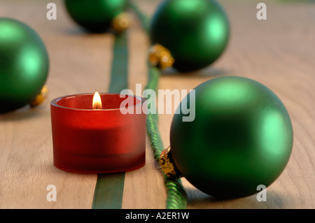 Decorazione di natale con candela che brucia e baubles di natale Foto Stock