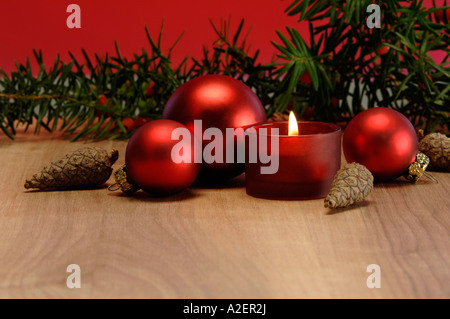 Decorazione di natale con candela che brucia e baubles di natale Foto Stock