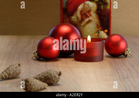 Decorazione di natale con candela che brucia e baubles di natale Foto Stock