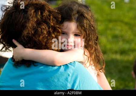 Figlia age 2 abbracciando la madre alla partita di calcio. Campo Carondelet da Expo scuola St Paul Minnesota USA Foto Stock