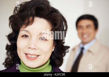 Ritratto di una donna matura sorridente con un uomo maturo dietro di lei Foto Stock