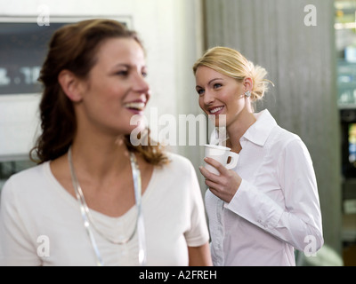 Due donne azienda bicchieri di carta Foto Stock