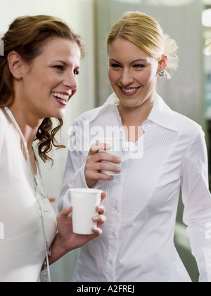 Due donne azienda bicchieri di carta Foto Stock