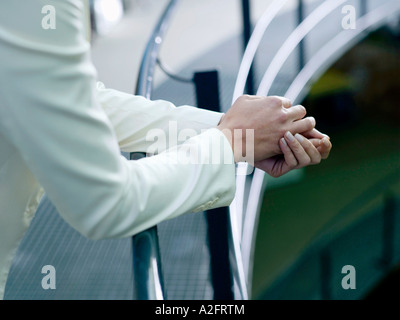 Imprenditrice appoggiata sulle ringhiere, metà sezione, close-up Foto Stock