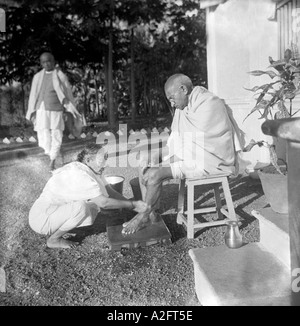 MKG33198 Kasturba Gandhi il lavaggio di suo marito Mahatma Gandhis piedi in Gujarat Bardoli India 1939 Foto Stock