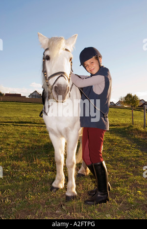 La ragazza (10-12) in piedi dal pony, ritratto Foto Stock