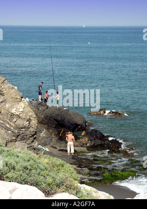 I giovani la pesca dalle rocce, El Faro, Mijas Costa, Costa del Sol, Spagna, Europa Foto Stock