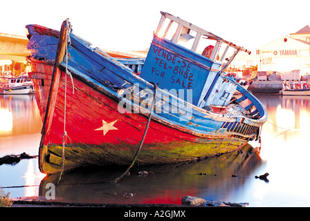 Vecchia barca ancoraggio a bassa marea nel fiume Gilao, alba nel porto di Tavira, Algarve, PORTOGALLO Foto Stock