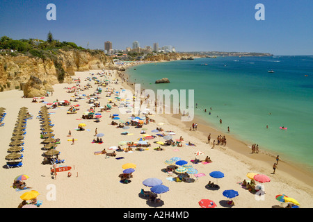 Il Portogallo Algarve Praia de Vau in estate, ombrelloni, la spiaggia e gli scogli. Praia da Rocha in distanza Foto Stock